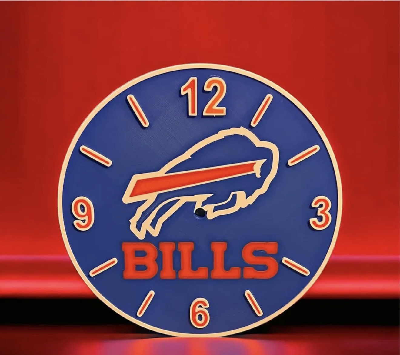 Custom blue and red 3D printed sports-themed clock face on a red background.