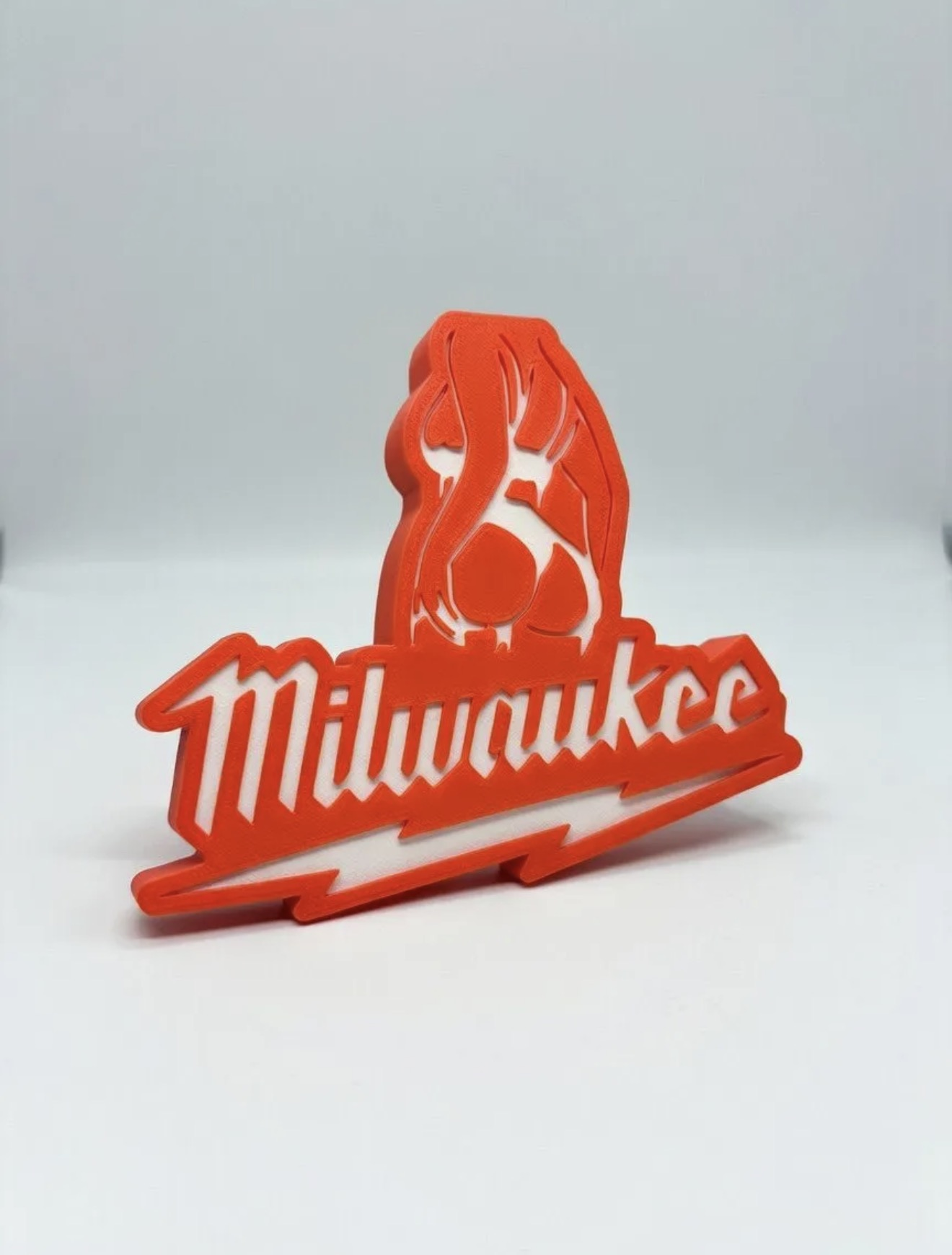 Custom red 3D printed display sign with white backing.