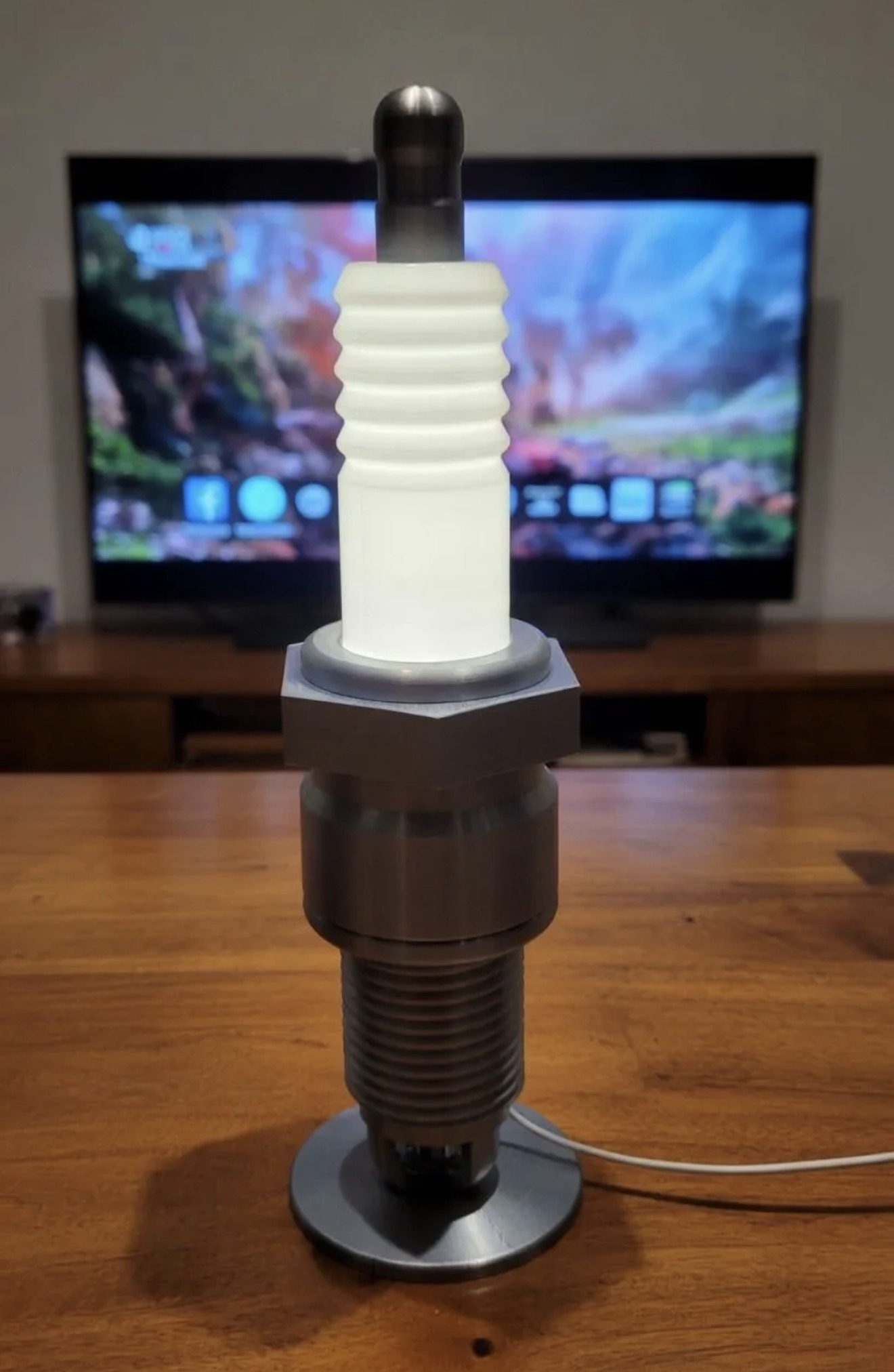 Custom 3D printed spark-plug-style light standing on a table.